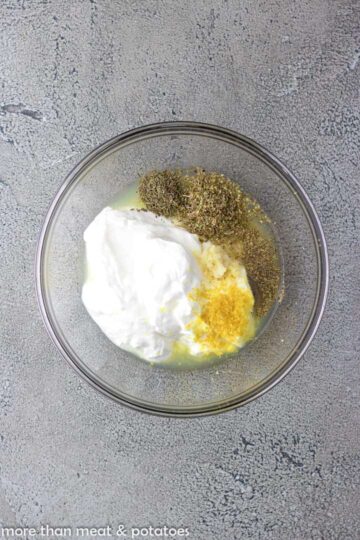 Ingredients for greek yogurt chicken marinade in a glass bowl.