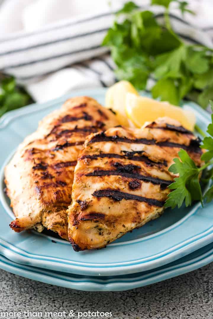 Grilled chicken with lemon slices and parsley.