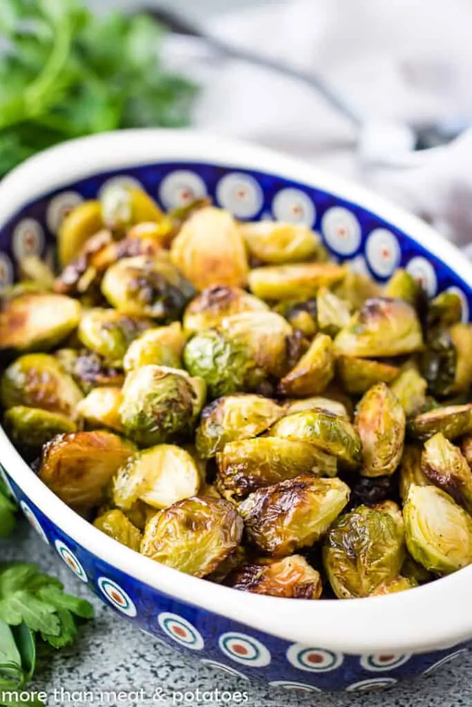 Roasted brussel sprouts in a colorful blue dish.