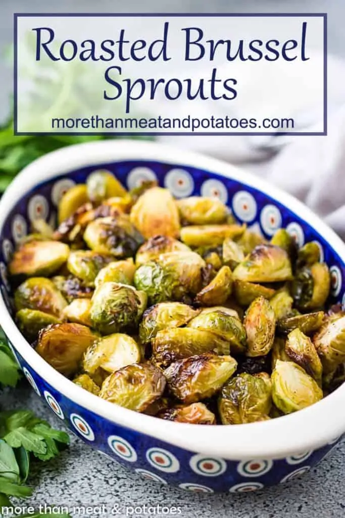A colorful serving dish filled with oven roasted brussel sprouts.