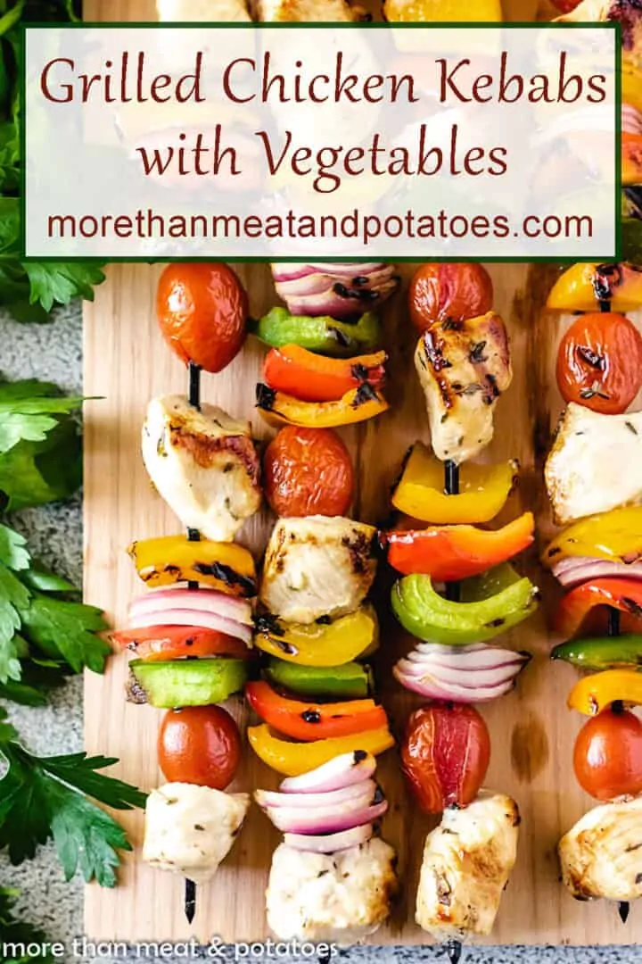 An aerial view of the grilled chicken with vegetables on a cutting board.