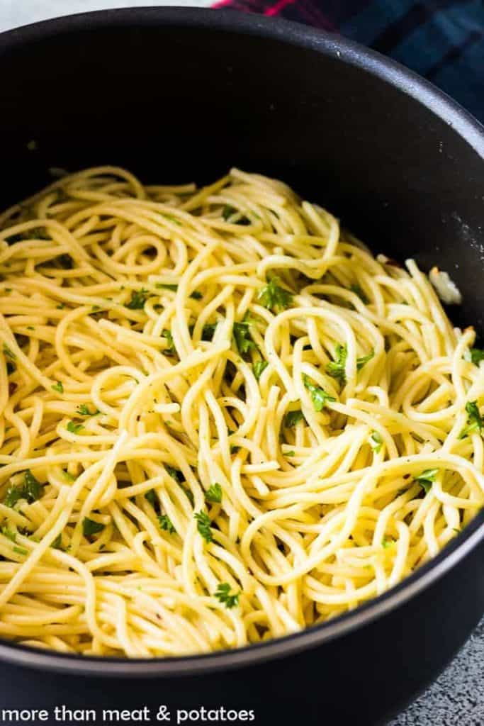 A close-up of the olive oil pasta with chopped parsley.