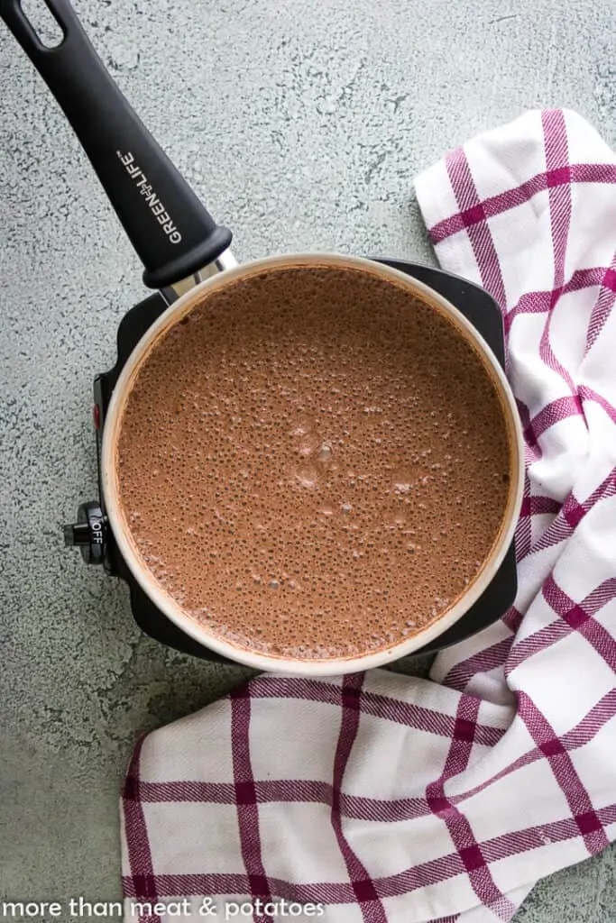 The chocolate pudding cooking in a saucepan.