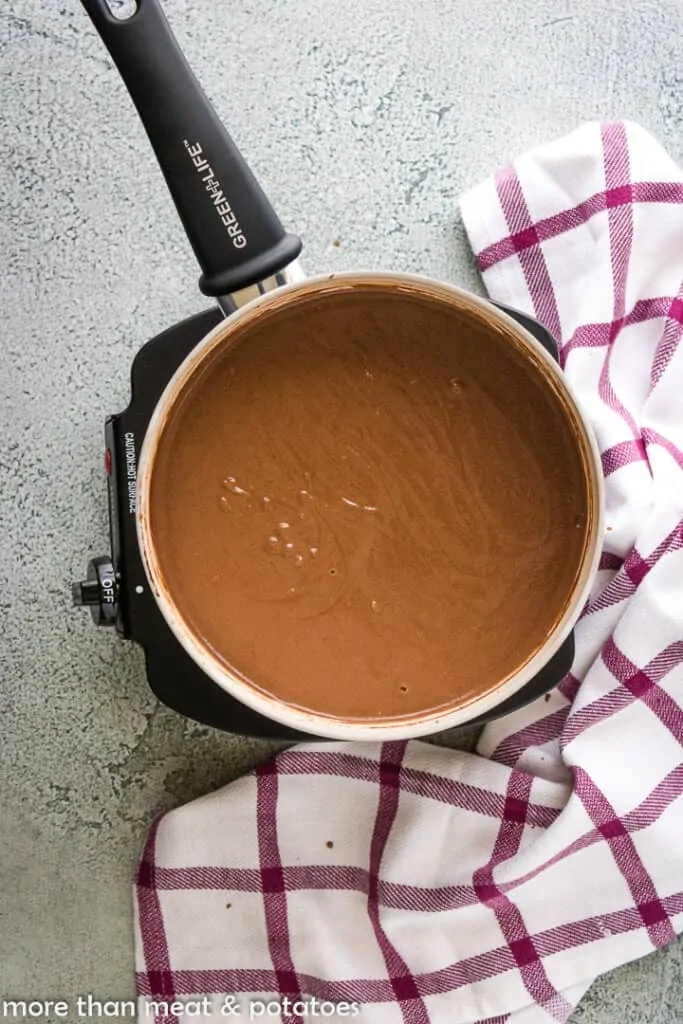 The cooked chocolate pudding in a saucepan.