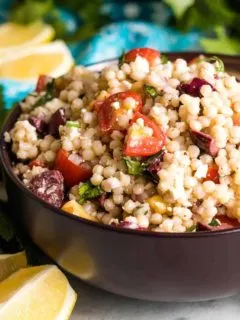 The lemon couscous salad served in brown bowl.