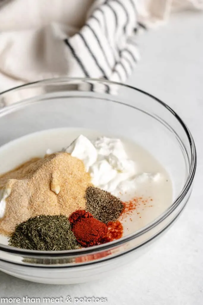 Buttermilk, sour cream, and spices in a mixing bowl.