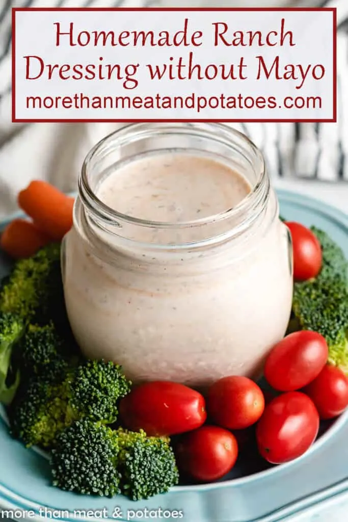 Homemade ranch dressing in a mason jar with fresh vegetables.