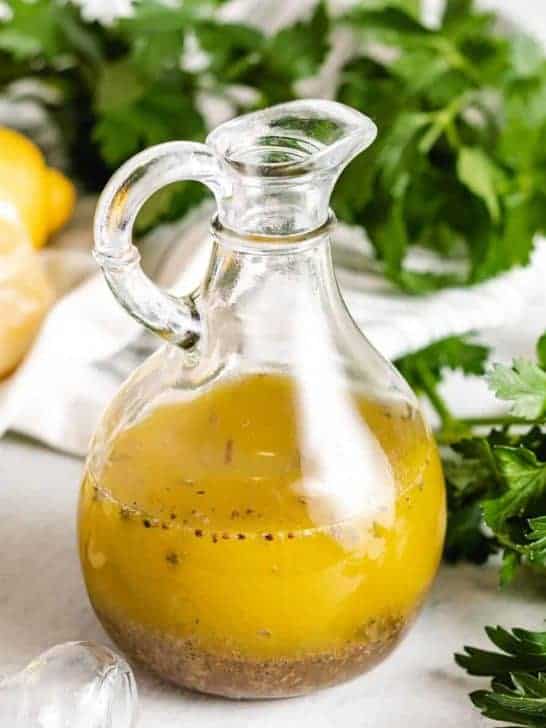 The lemon basil vinaigrette in a glass cruet.