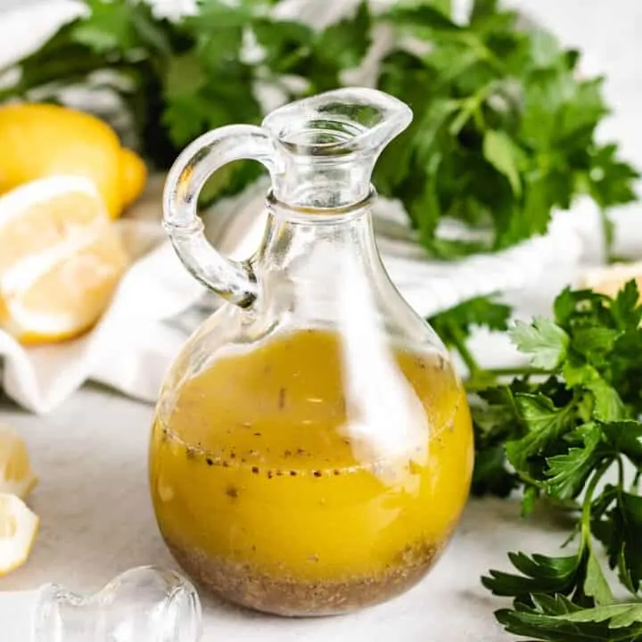 The lemon basil vinaigrette in a glass cruet.