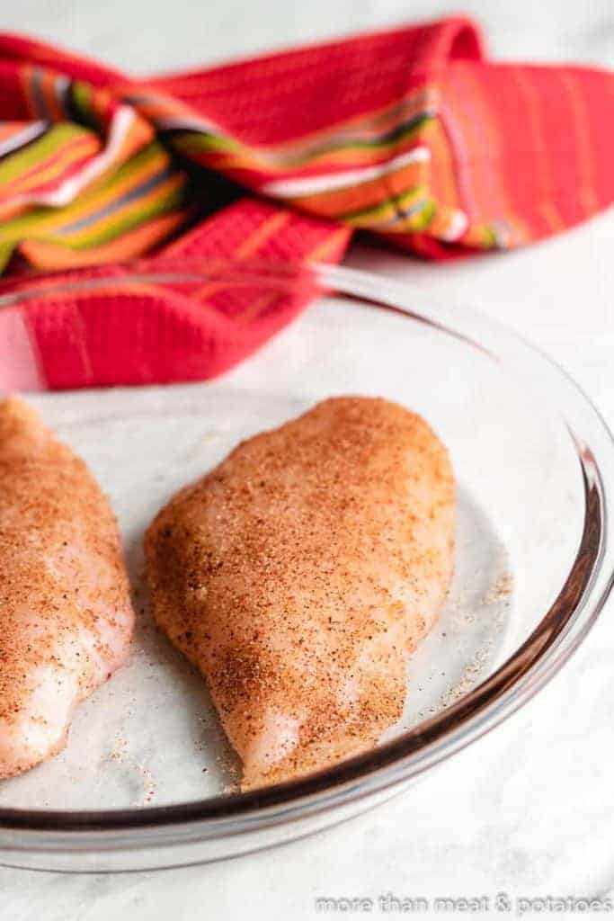 Raw chicken breasts seasoned with Tex-Mex spices.