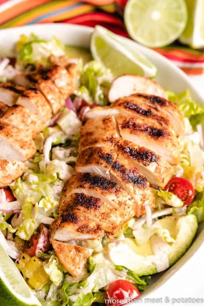 The sliced grilled poultry atop a bed of lettuce.