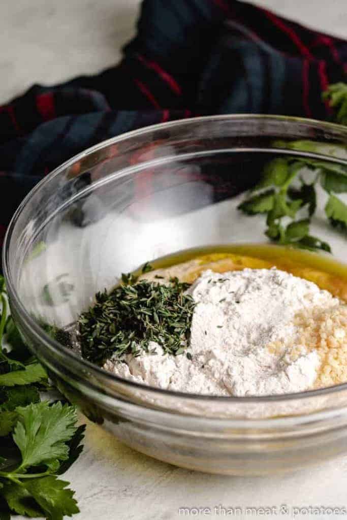 Flour, herbs, and other ingredients in a mixing bowl.
