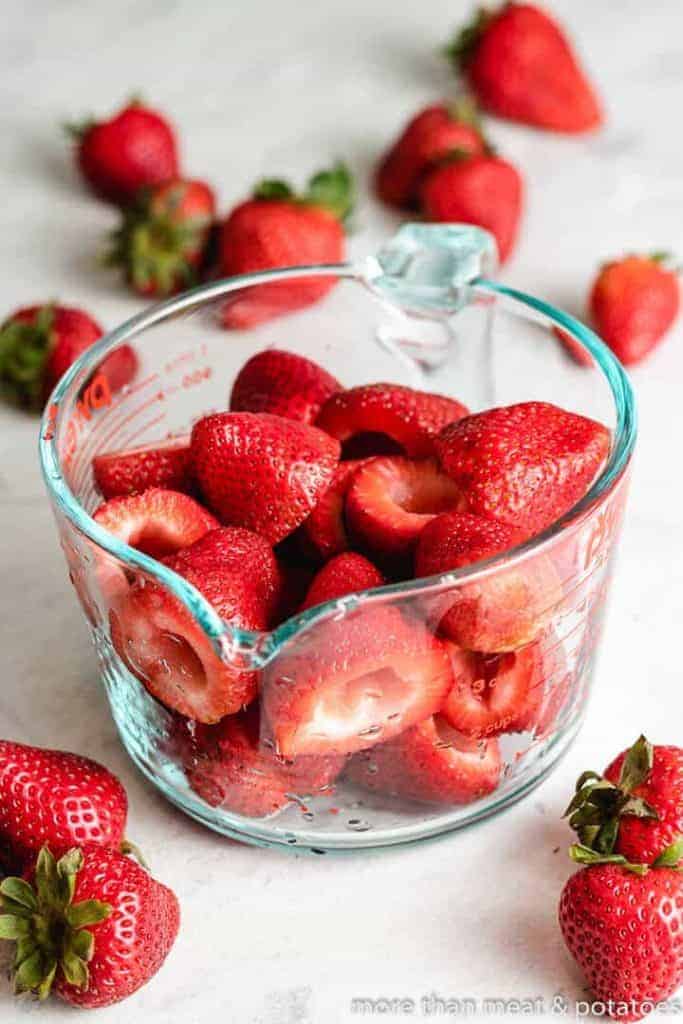 Fresh strawberries in a measuring cup.