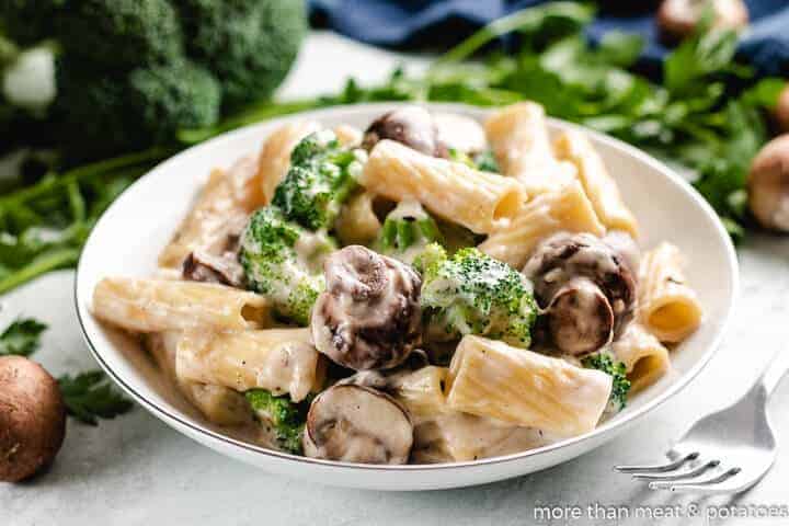 Mushroom pasta with broccoli florets in a bowl.