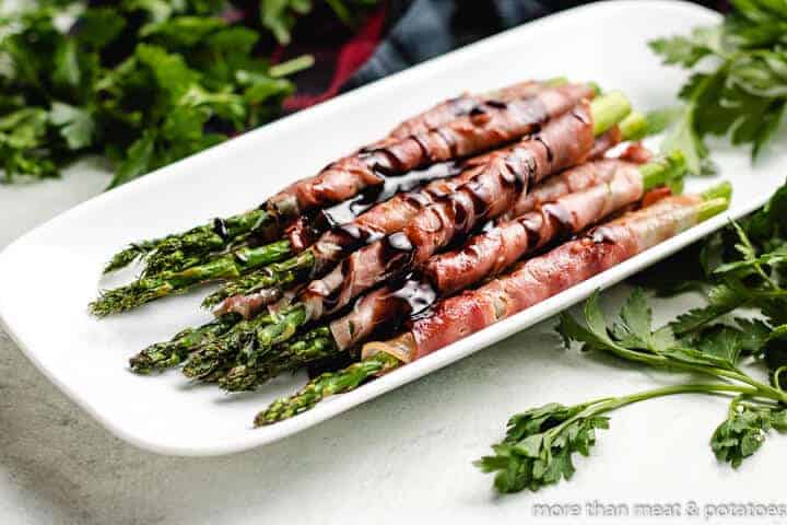 Grilled Prosciutto Wrapped Asparagus The finished asparagus topped with a balsamic glaze.