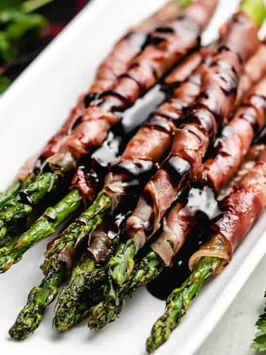 The prosciutto wrapped asparagus on a serving platter.