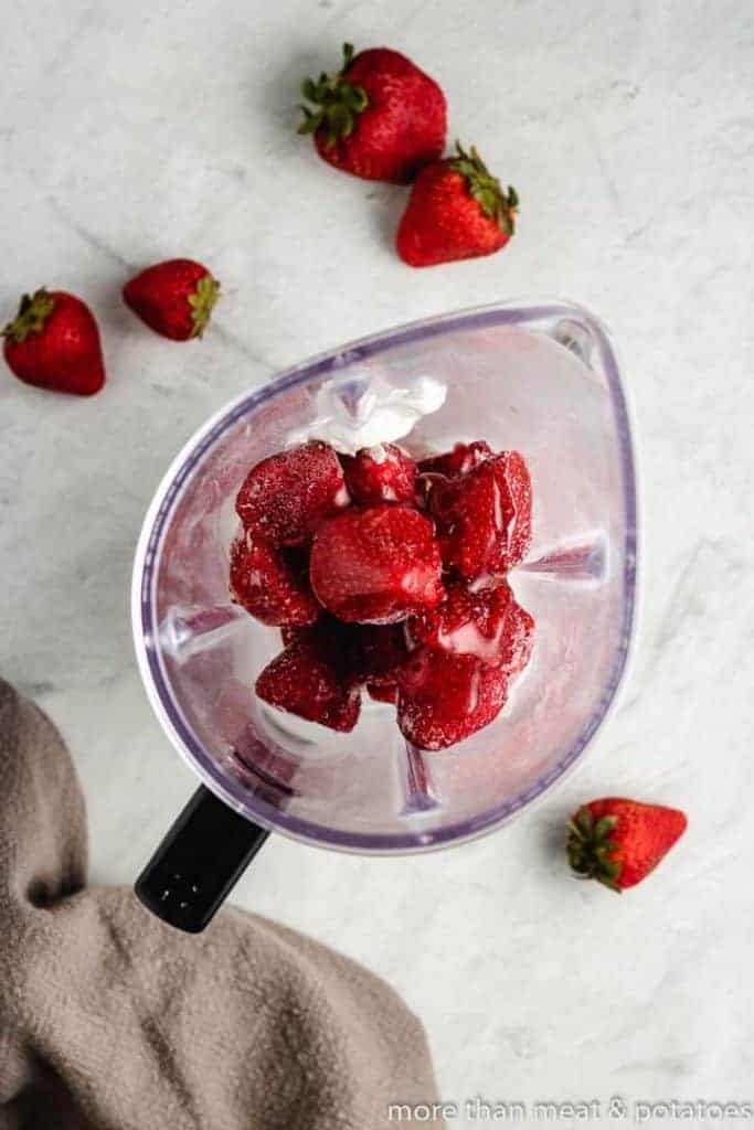 The frozen berries have been placed into a blender.