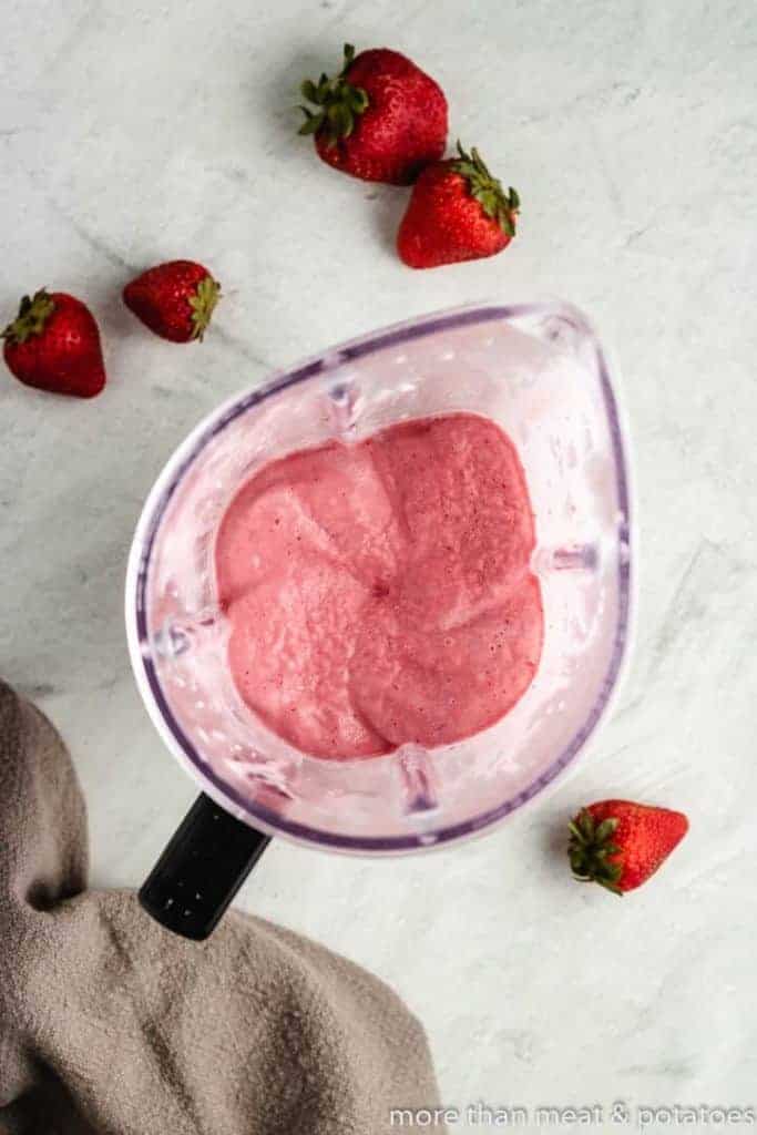 Berries, yogurt, and other ingredients blending in the appliance.