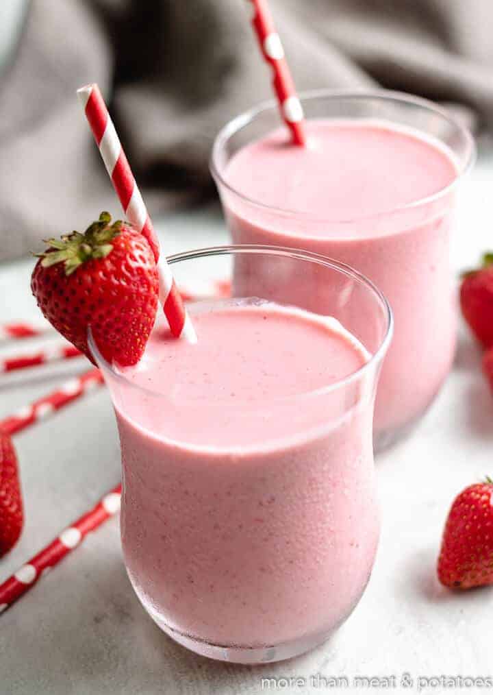 The finished smoothies served with fresh berries and colorful straws.