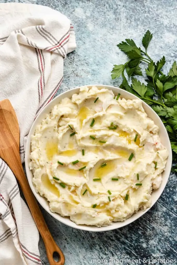 An aerial view of the potatoes topped with butter and chives.