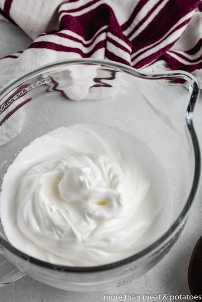 Heavy cream whipped in a mixing bowl.