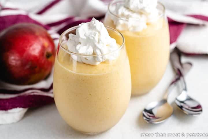 Mango Mousse Two glasses of the mango mousse with whipped cream.