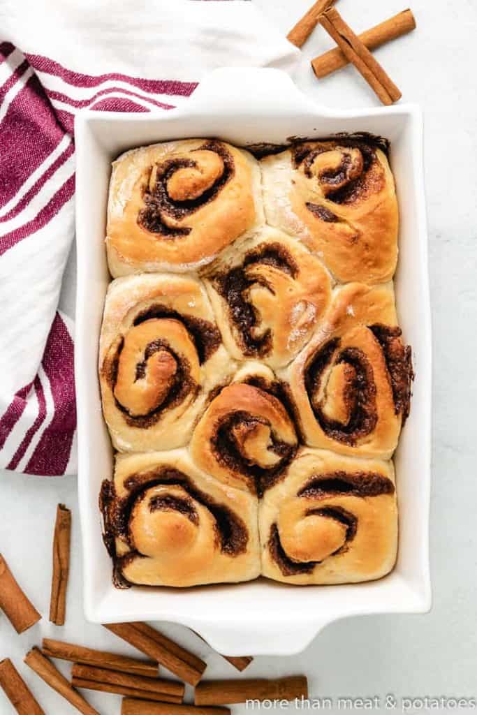 The cinnamon rolls have baked in a dish.