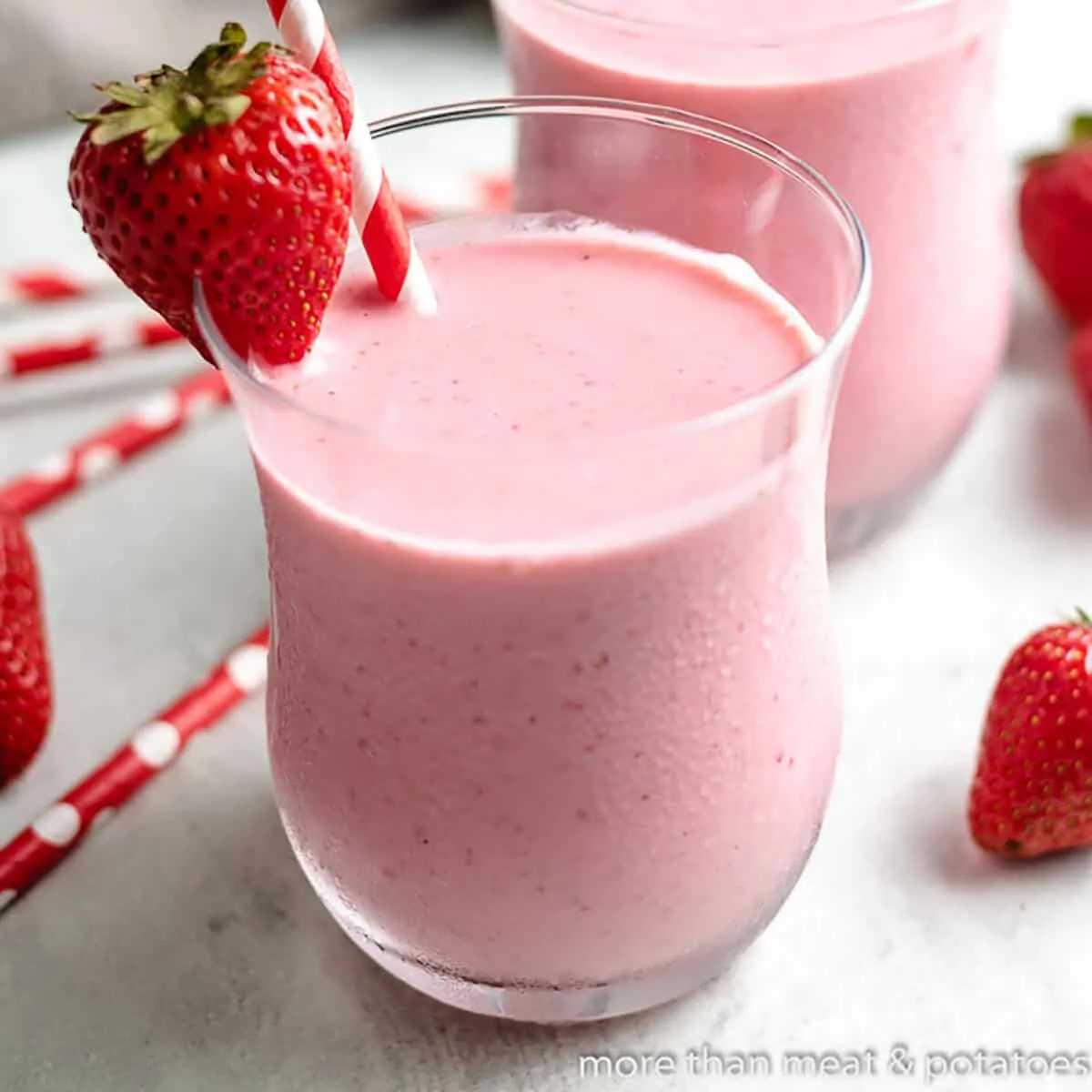 The finished strawberry greek yogurt smoothie with a straw.