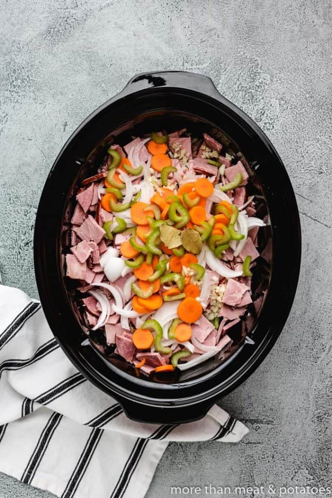 All of the ingredients have been added to a slow-cooker.