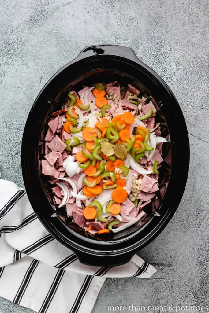 All of the ingredients have been added to a slow-cooker.