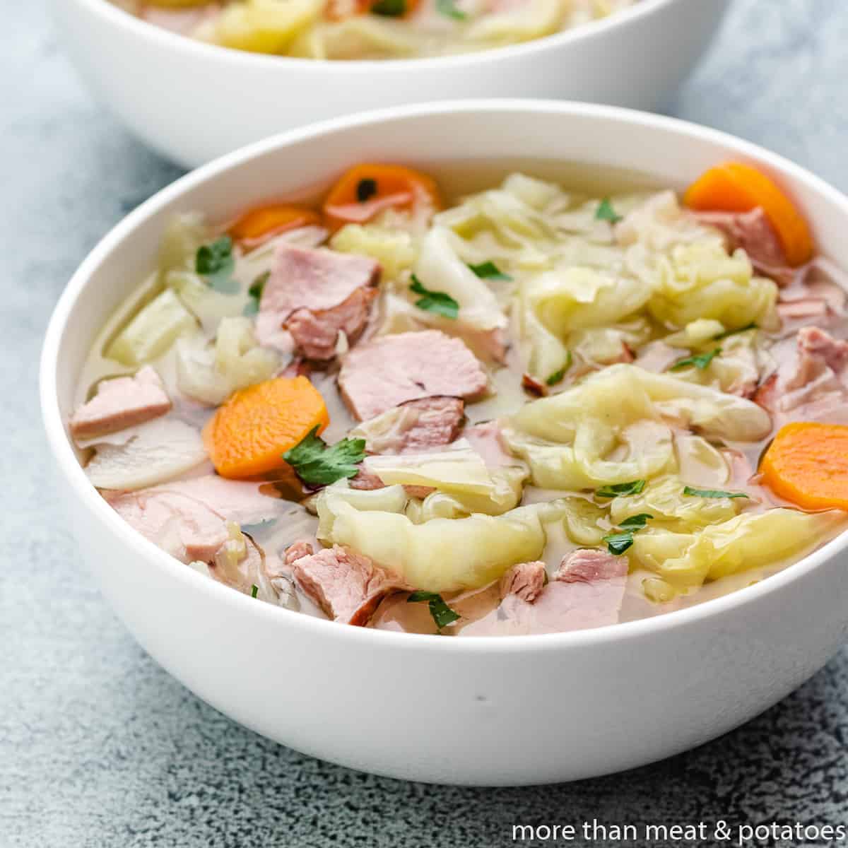 The ham and cabbage soup served in a bowl.