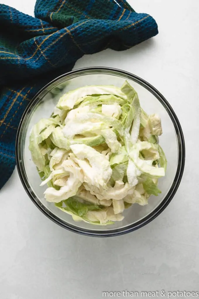 Chopped and uncooked cabbage in a mixing bowl.