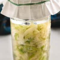 Un-fermented sauerkraut in a mason jar topped with a coffee filter.