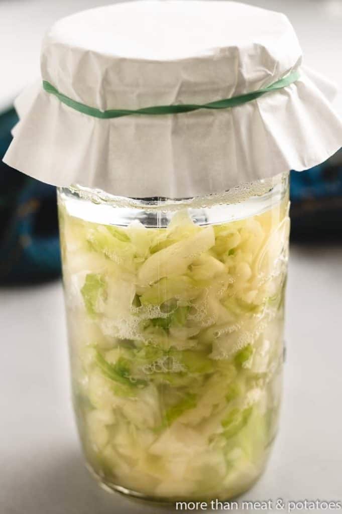 Un-fermented sauerkraut in a mason jar topped with a coffee filter.