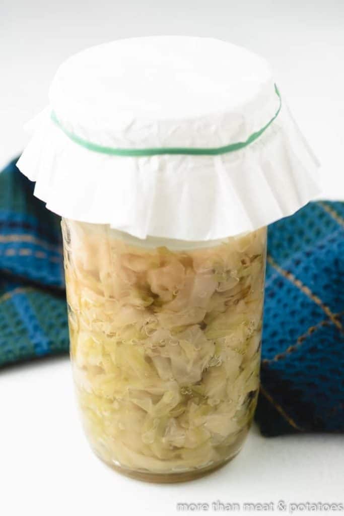 The cabbage changes color while fermenting in the jar.