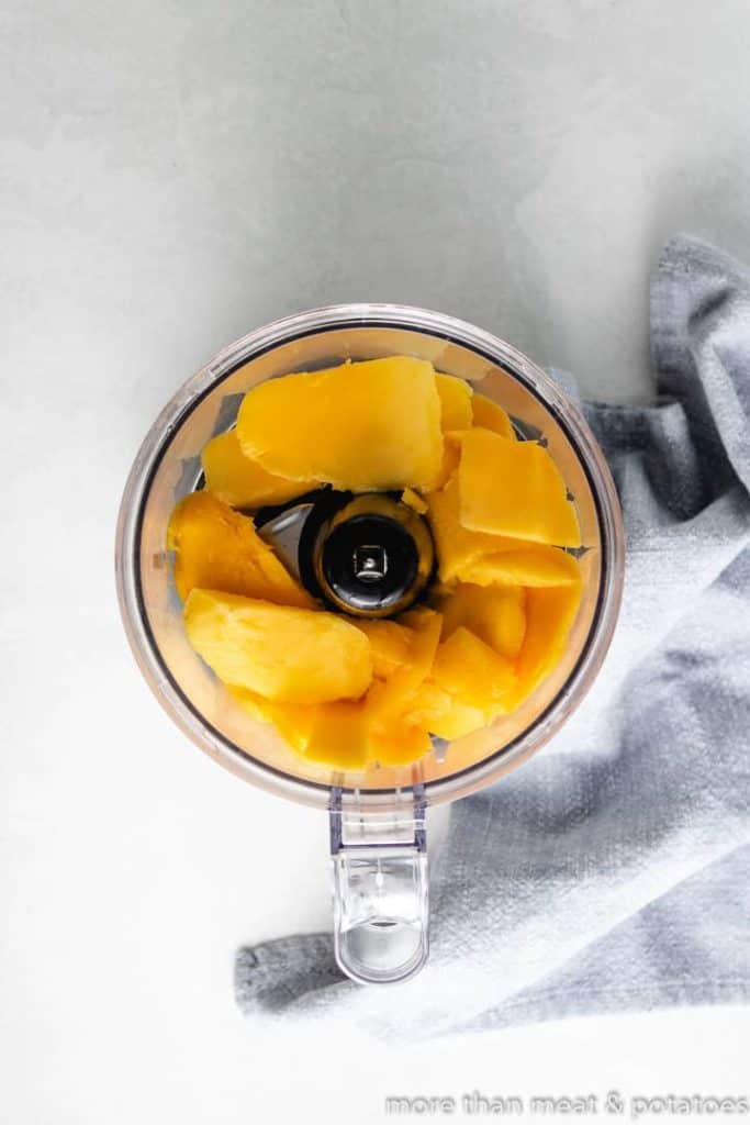 Chunks of mango in a food processor.