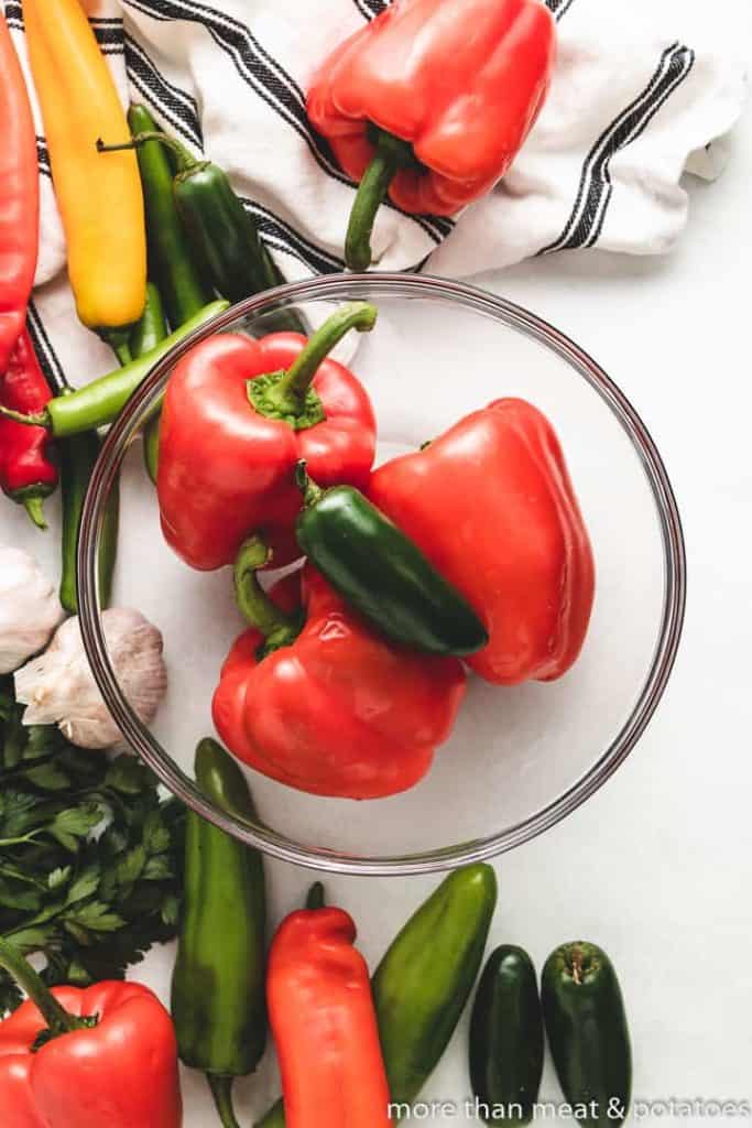 Fresh bell peppers and a jalapeno in a bowl.