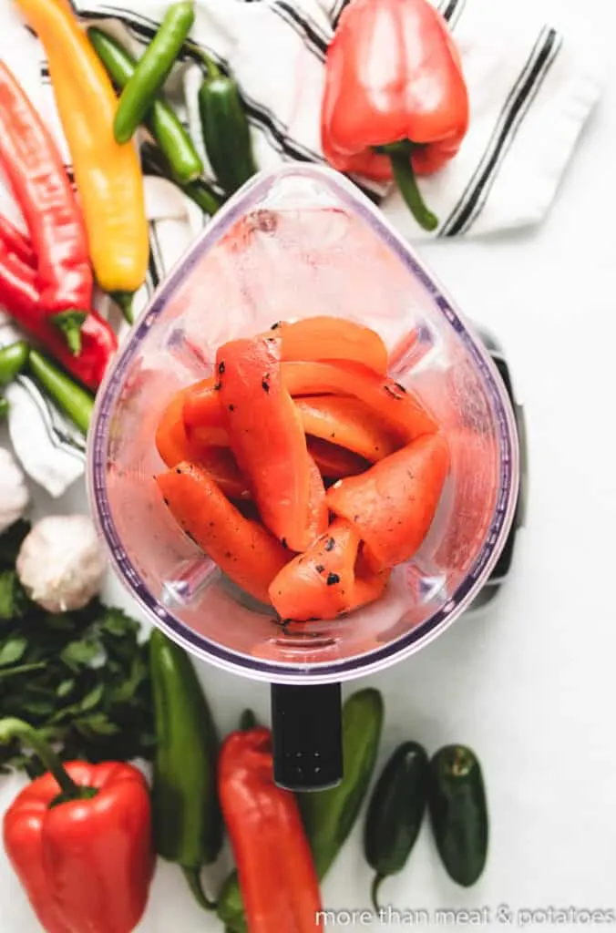 An aerial view of peeled peppers in a blender.