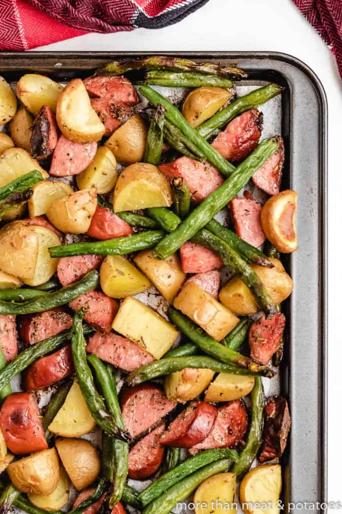 The cooked meat and veggies on a sheet pan.