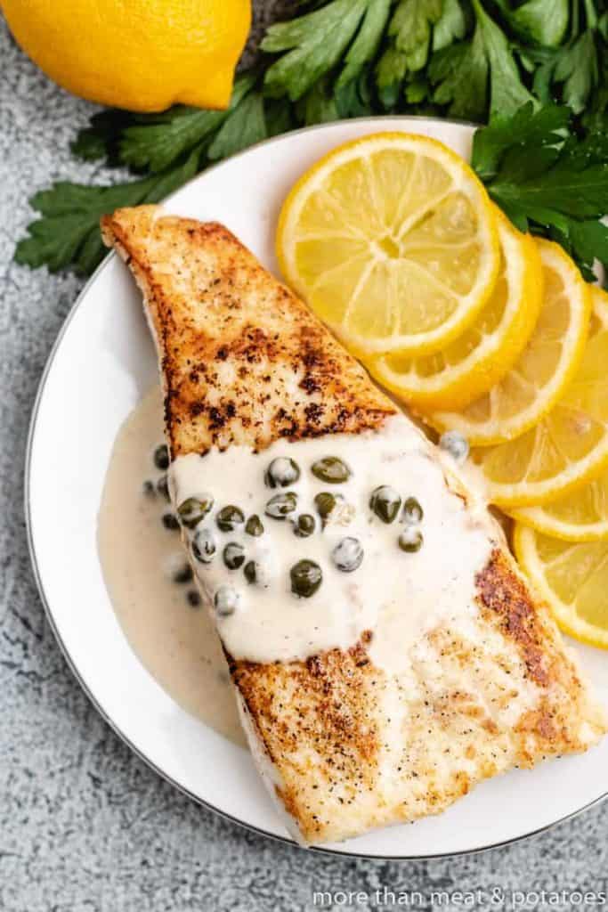 A top-down view of cooked fish covered in sauce.