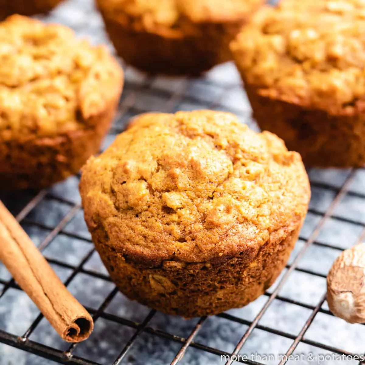 Four pumpkin oatmeal muffins on a cooling rack.