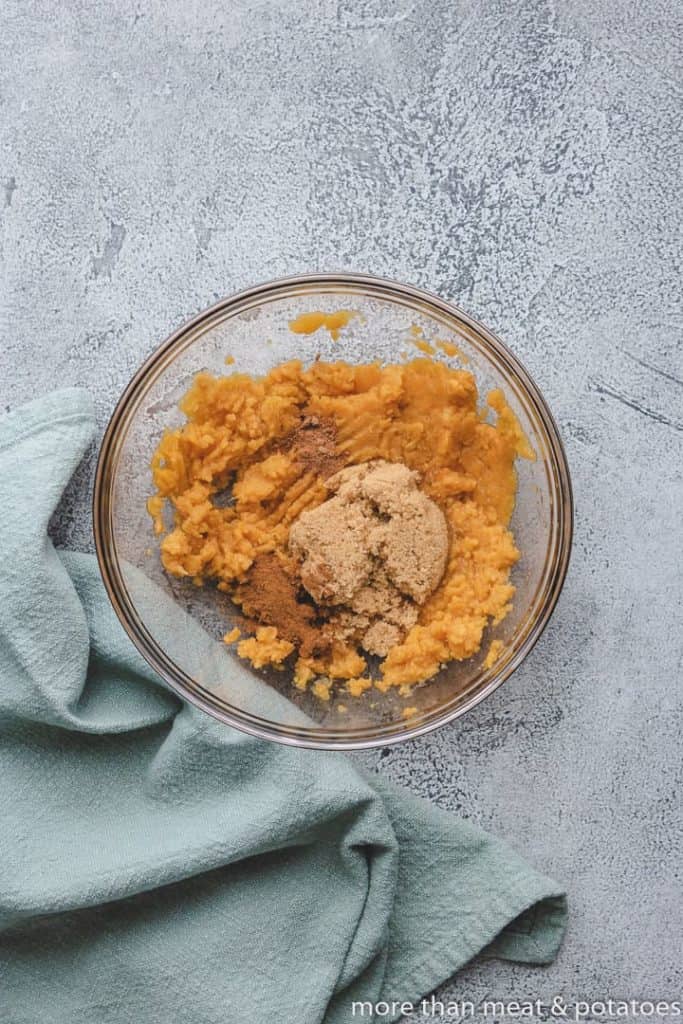 Mashed sweet potatoes and brown sugar in a bowl.