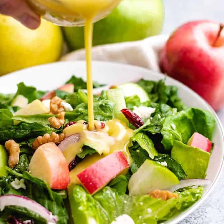 The salad being dressed with an apple cider vinaigrette.
