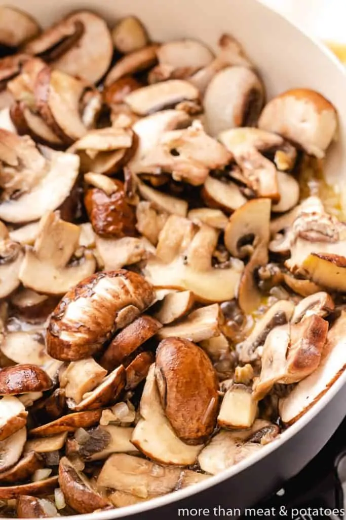 Fresh mushrooms added to the oil and onions.