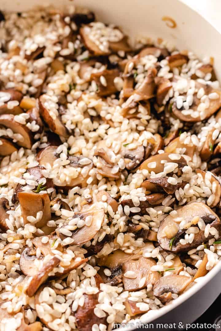 Dry Arborio rice added to the mushrooms.