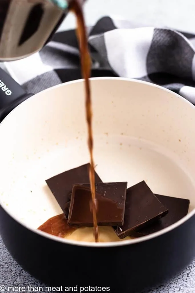 Hot coffee being poured over chocolate squares.