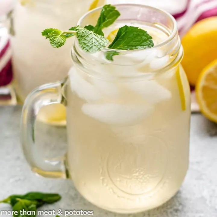 Two mugs of ginger infused mugs with ice and mint.