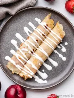 Two Hungarian pancakes drizzled with sour cream sauce.