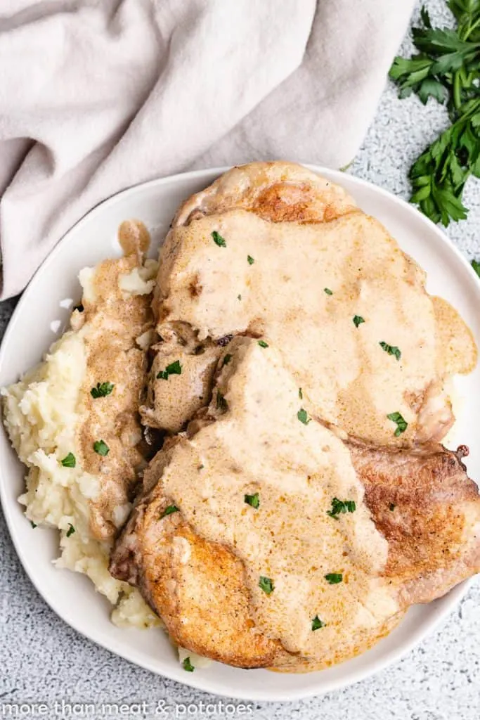 An aerial view of pork chops with sour cream gravy.