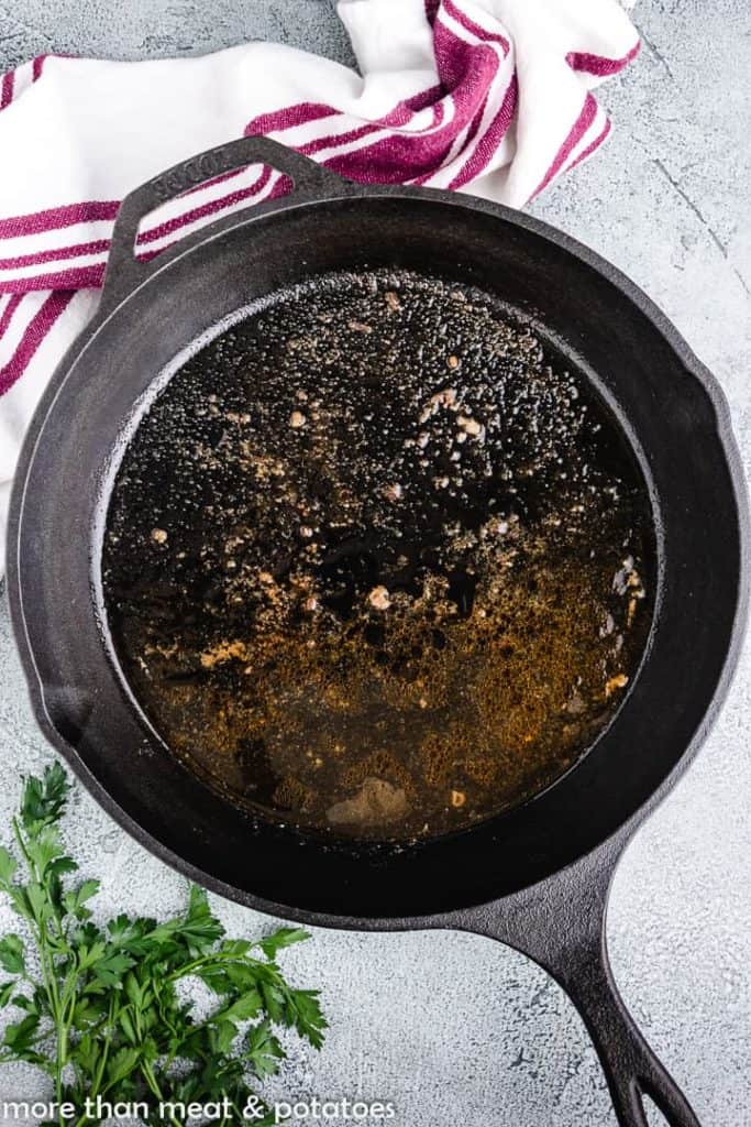 Pan drippings in a cast iron skillet.